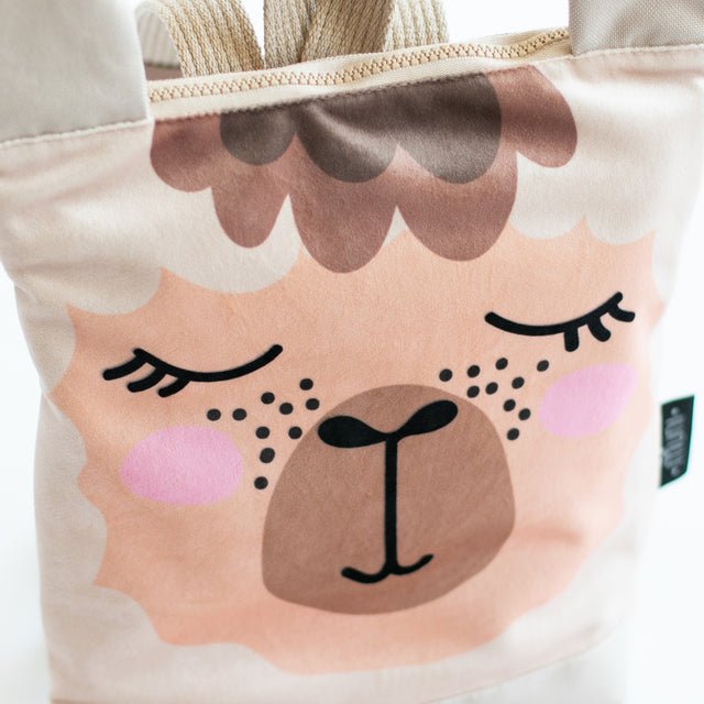7. Close-up of Muni llama backpack, highlighting printed llama face and velvet fabric