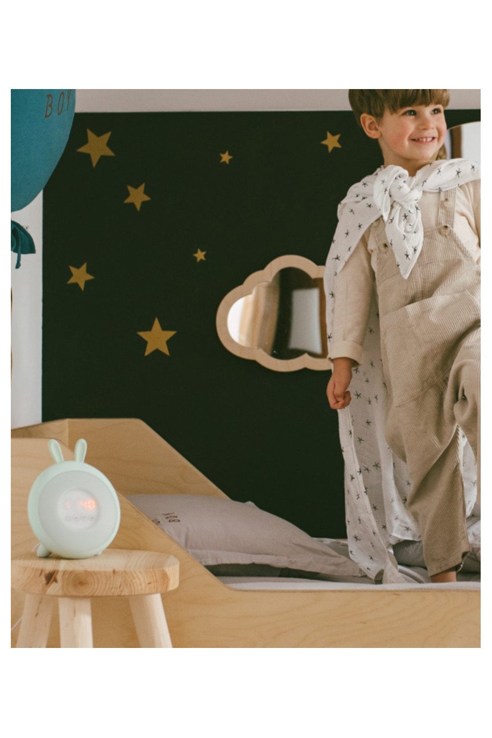 5. Child in playroom with green Rabbit & Friends lamp with alarm clock on wooden stool, starry wall background