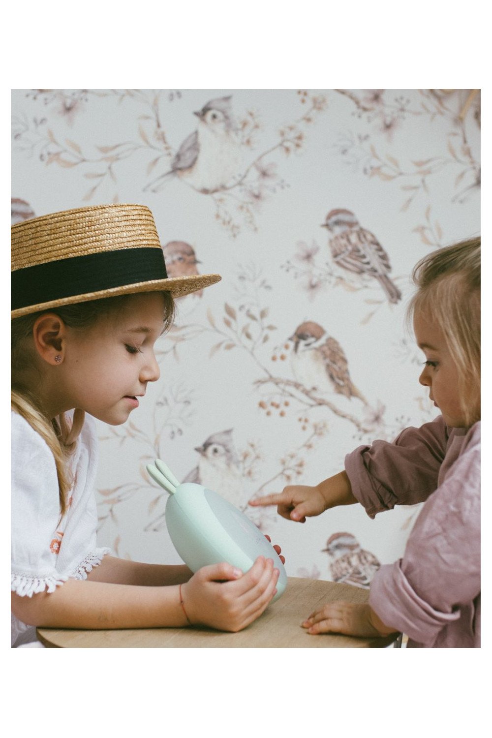 4. Two children interacting with green Rabbit & Friends lamp with alarm clock, in room with bird wallpaper