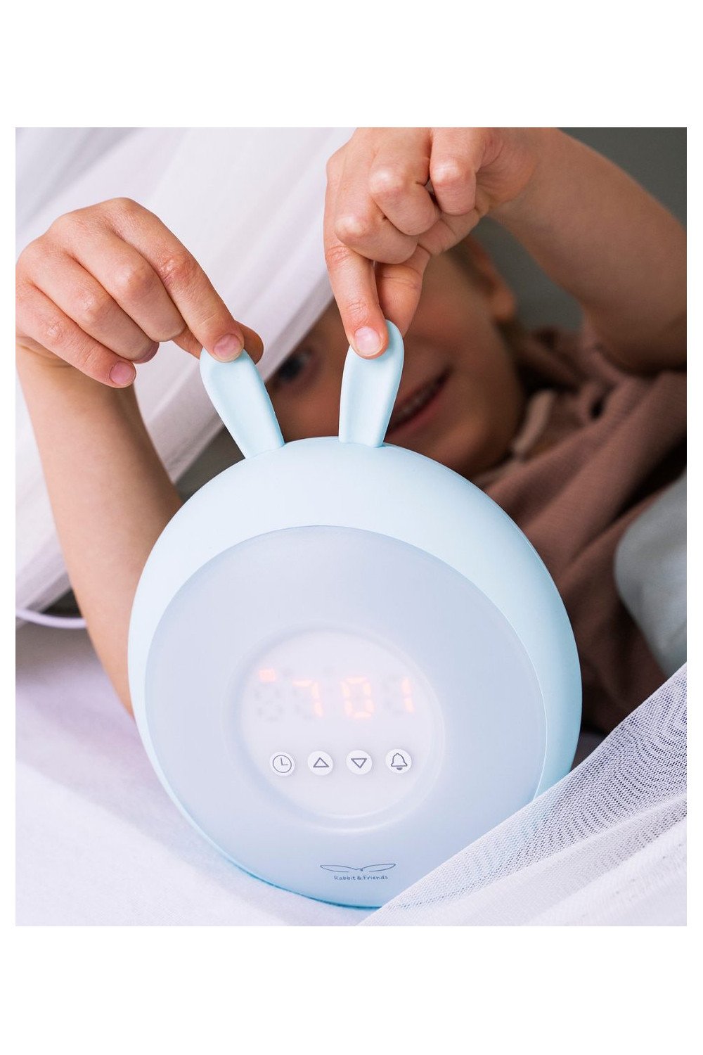 1. Child interacting with blue Rabbit & Friends alarm lamp with ears, displaying digital time in cozy bedroom setting