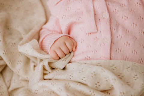 5. Close-up of baby hand holding cream merino wool blanket