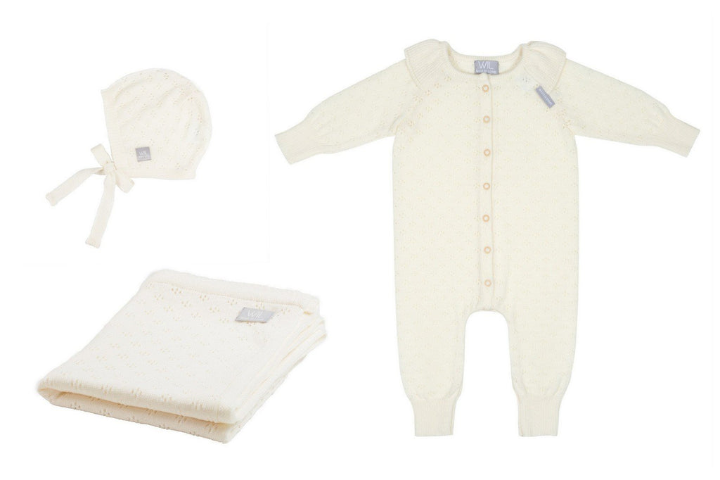 4. Flat lay of cream merino wool romper, bonnet, and blanket set