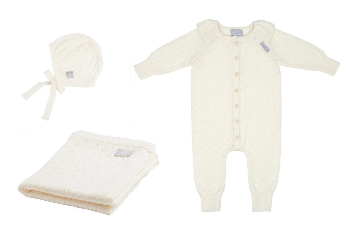 4. Flat lay of cream merino wool romper, bonnet, and blanket set