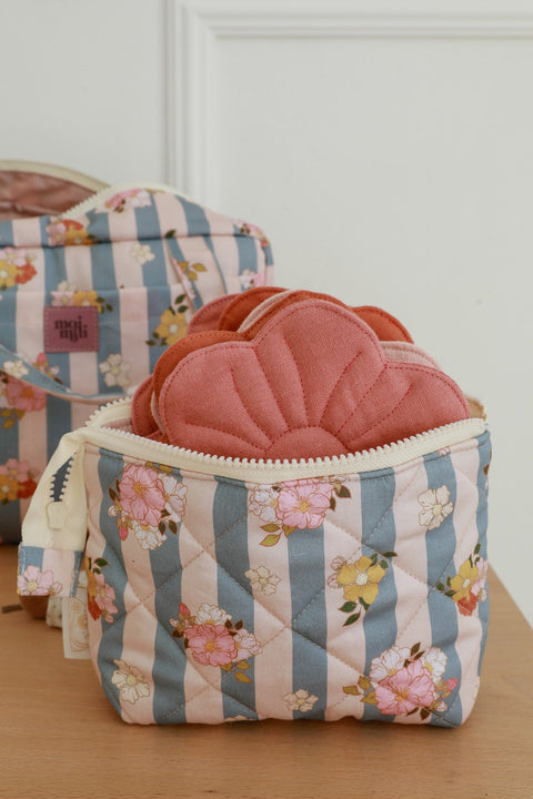 3. Small blue striped makeup bag with floral print, open to show pink quilted items inside