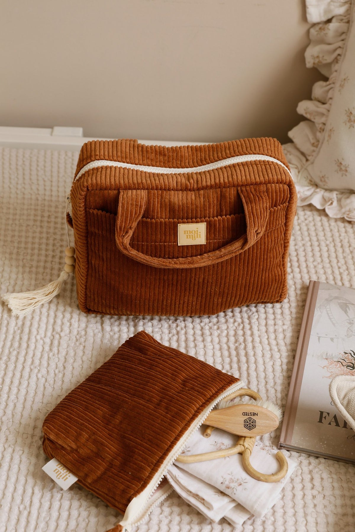 5. Caramel makeup bag on a textured surface with smaller pouch, scissors, and fabric, emphasizing its multifunctional use