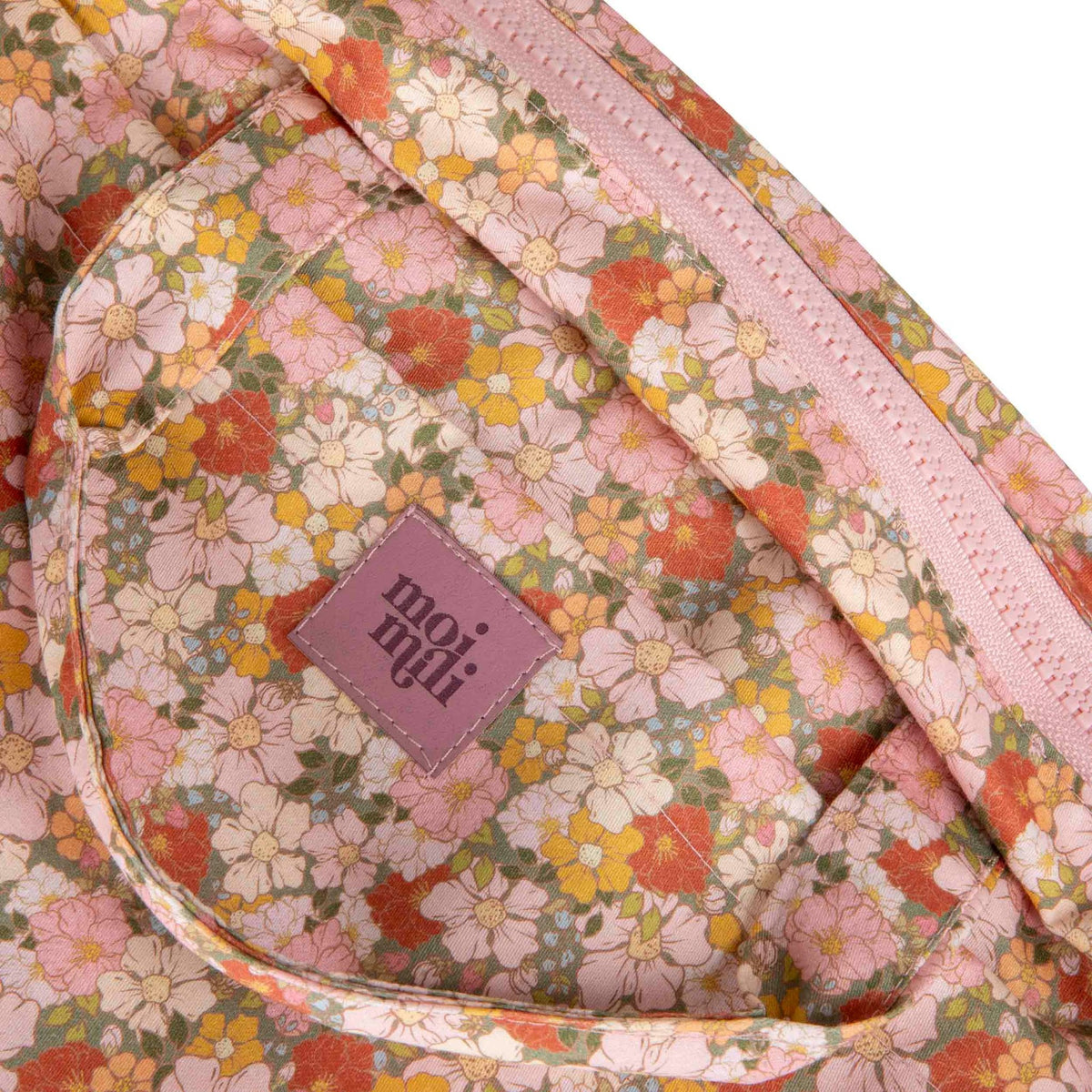 3. Close-up of moi mili logo on floral print makeup bag with pink and orange flowers