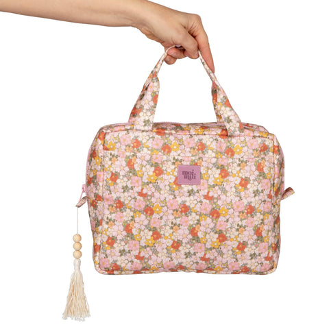 2. Hand holding large floral print makeup bag with pink and orange flowers, featuring tassel detail