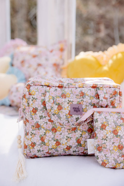 1. Moi Mili large makeup bag with floral print and matching smaller bag on outdoor setting