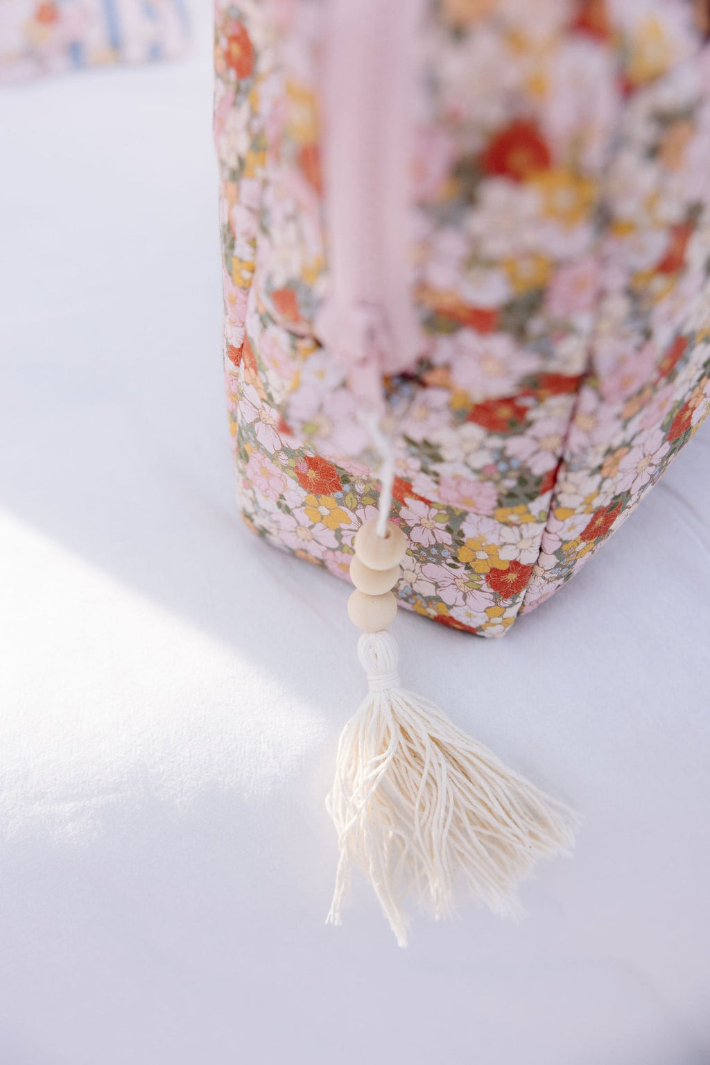 3. Detail of floral print on Moi Mili makeup bag with tassel and bead accent