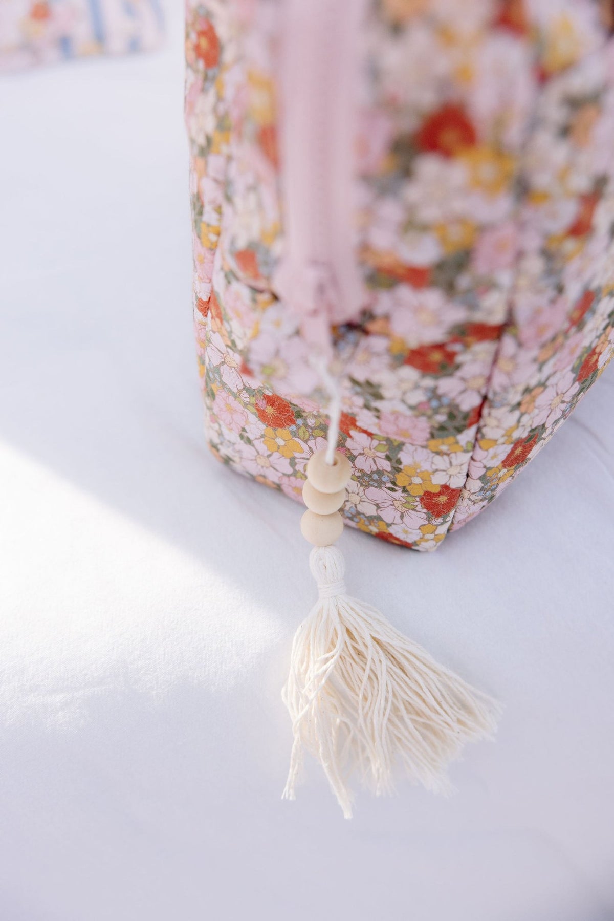 3. Detail of floral print on Moi Mili makeup bag with tassel and bead accent