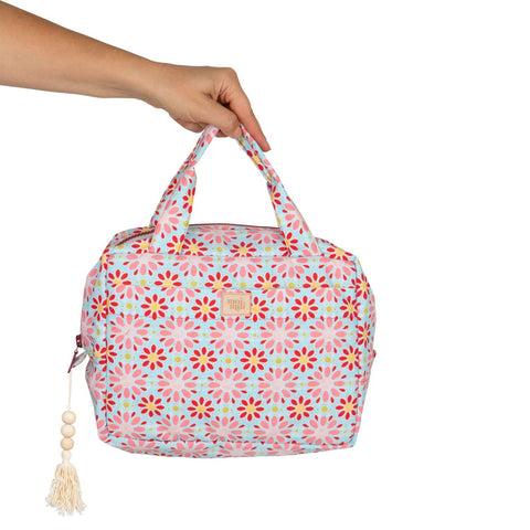 5. Hand holding Moi Mili large makeup bag with red flower print against white background