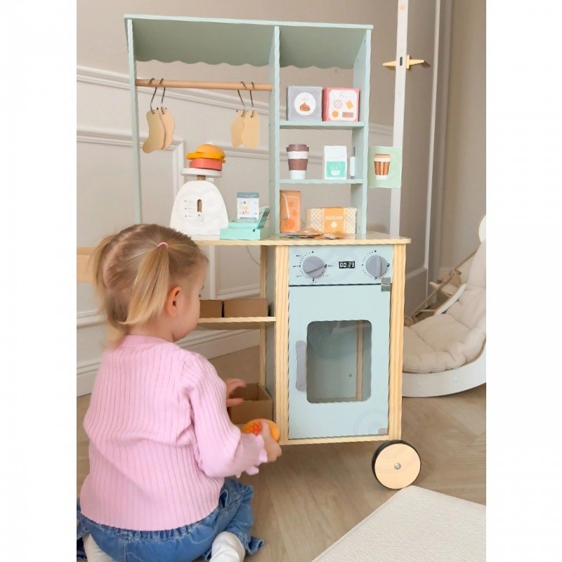 7. Child playing with Woopie Green wooden food truck stand, side view