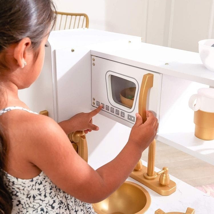 7. Girl interacting with microwave on Angelove white and gold play kitchen