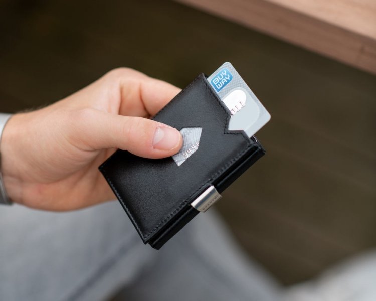 1. Person holding black EXENTRI leather wallet with card partially visible, showcasing quick access feature