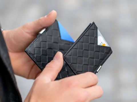 1. Person holding two black EXENTRI wallets with chess pattern, showing card slots