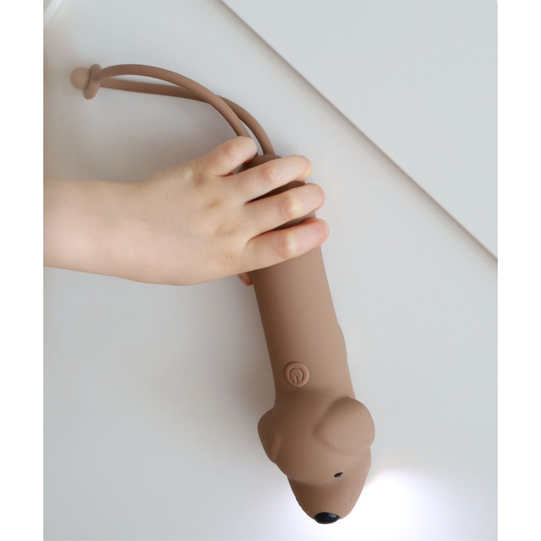 3. Child holding brown dog-shaped silicone flashlight, demonstrating easy grip and usability for kids.