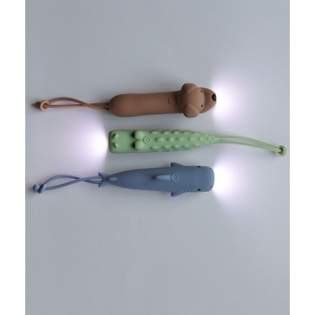 4. Flat lay of three animal-shaped flashlights in brown, green, and blue with lights on