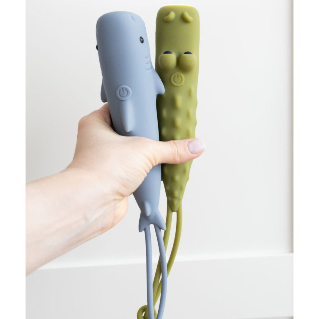 1. Hand holding two animal-shaped flashlights in blue and green against white background