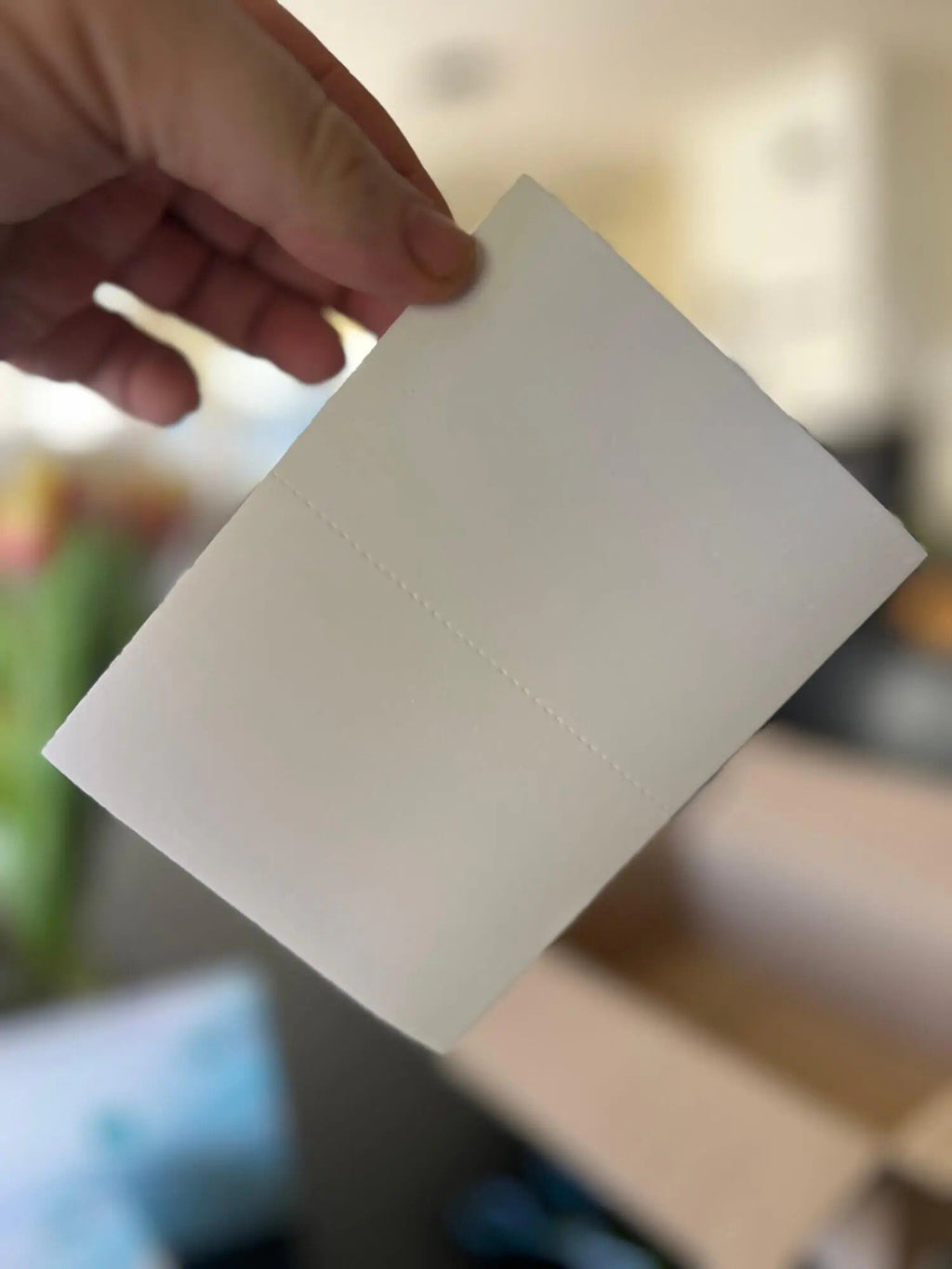 3. Close-up of a hand holding a single GoGoNano laundry detergent sheet, highlighting its thin and lightweight design
