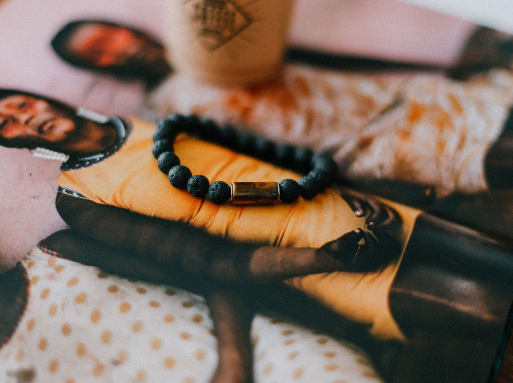 3. Men's lava bracelet with 8mm tiger eye bead by Canary Lava displayed on magazine