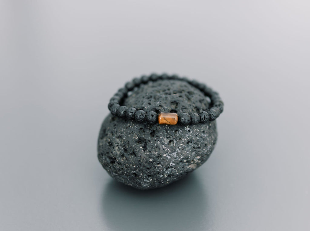 2. Men's Canary Lava bracelet with tiger eye bead displayed on volcanic rock