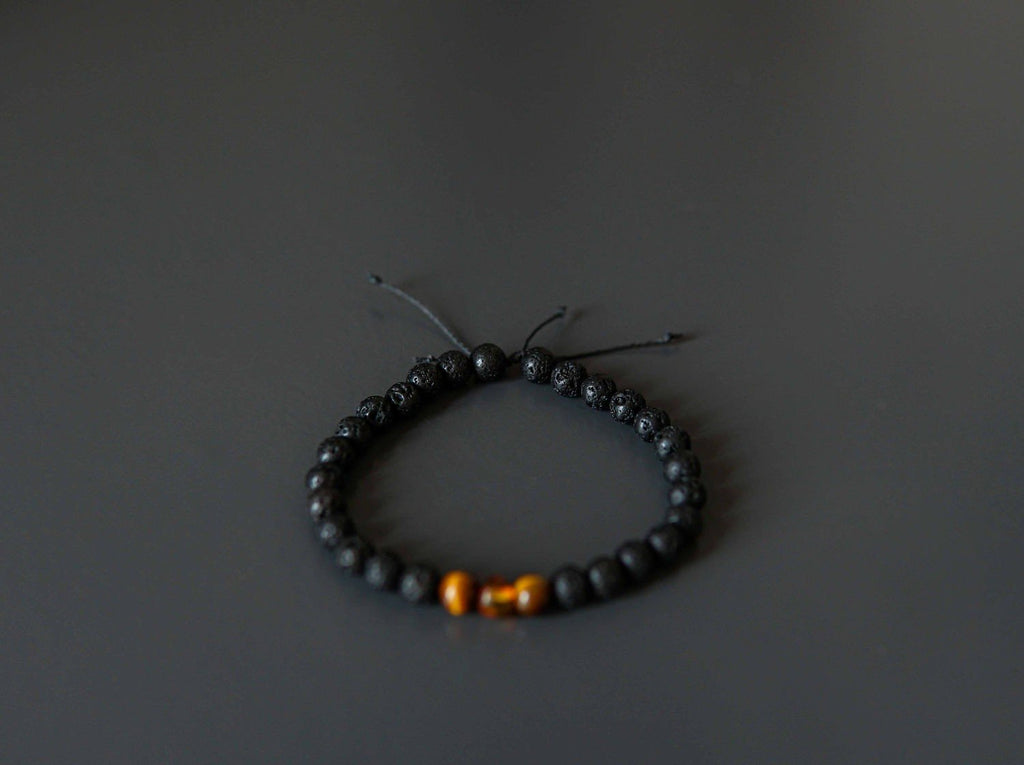 3. Studio shot of Canary Lava Stone Bracelet with Amber and Tiger Eye beads on black background