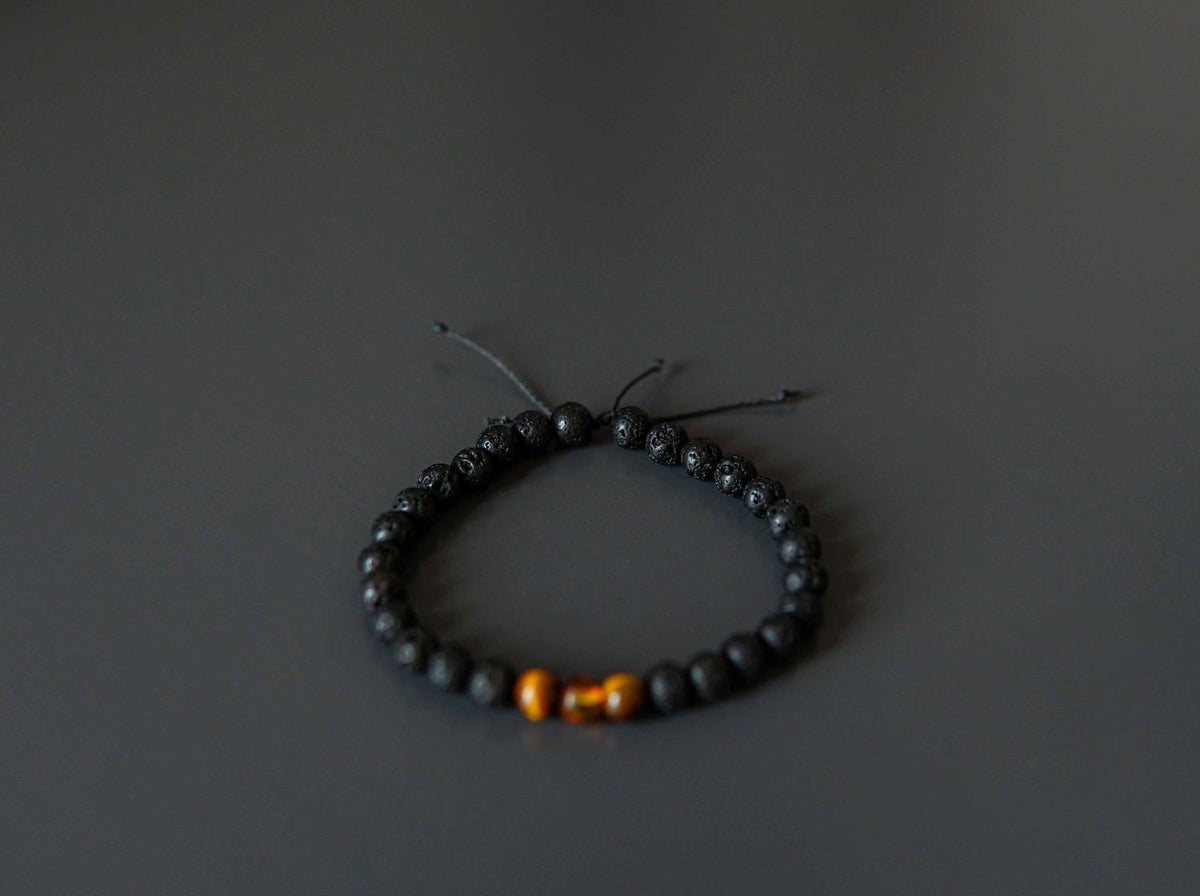 3. Studio shot of Canary Lava Stone Bracelet with Amber and Tiger Eye beads on black background