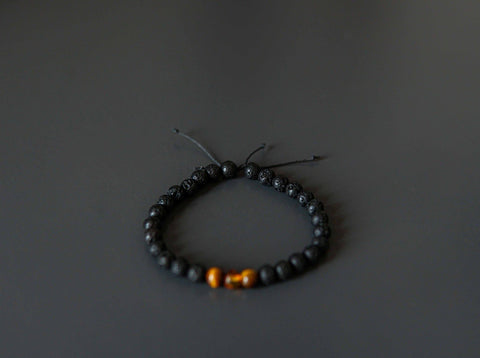 3. Studio shot of Canary Lava Stone Bracelet with Amber and Tiger Eye beads on black background
