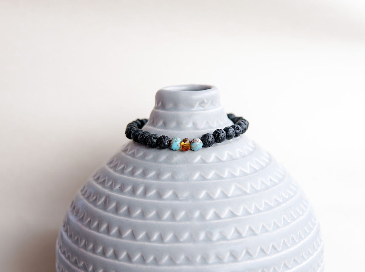 3. Lava stone bracelet with amber and turquoise by Canary Lava, displayed on a decorative vase