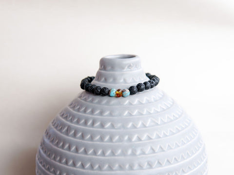 3. Lava stone bracelet with amber and turquoise by Canary Lava, displayed on a decorative vase