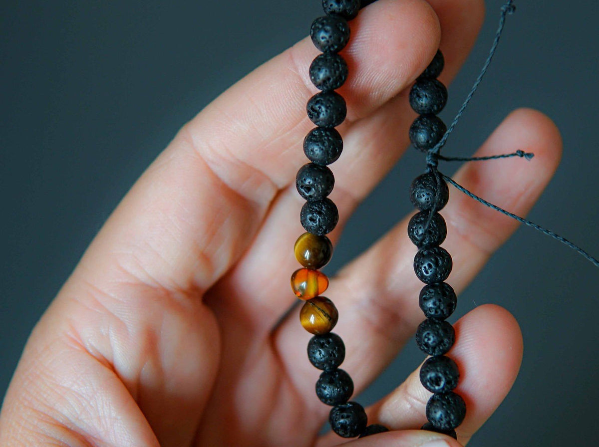 2. Close-up of Canary Lava Stone Bracelet with Amber and Tiger Eye beads held in hand