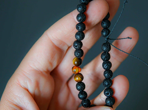 2. Close-up of Canary Lava Stone Bracelet with Amber and Tiger Eye beads held in hand
