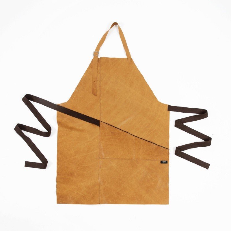 4. Flat lay of KOOSdisain camel brown leather apron with pocket and brown cotton belt, shown on white background
