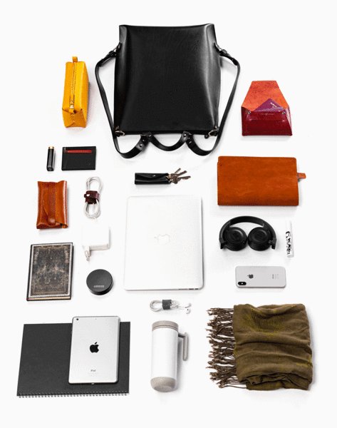 10. Flat lay of black leather backpack by Stella Soomlais with various accessories and gadgets