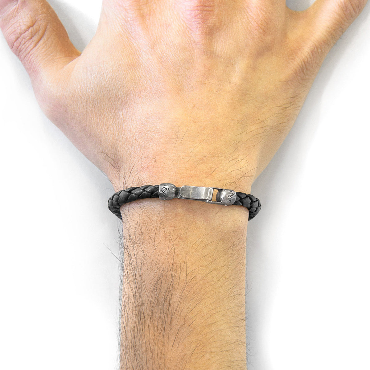 1. Men's black braided leather bracelet with sterling silver clasp by ANCHOR & CREW, shown on wrist