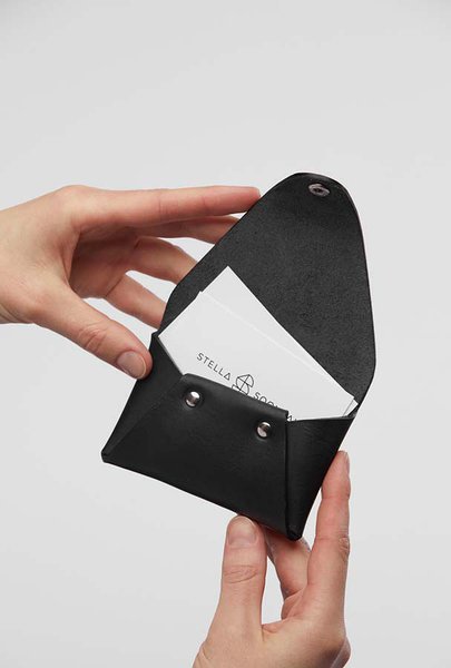 4. Hands opening black leather coin pouch with Stella Soomlais cards inside