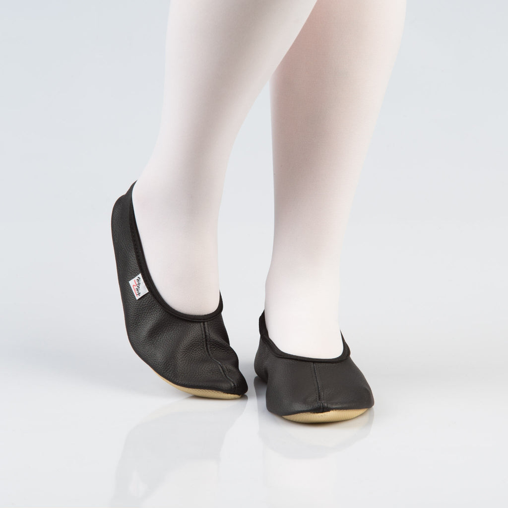 2. Women's black leather gymnastics slippers with rubber sole, shown from front on model wearing white tights