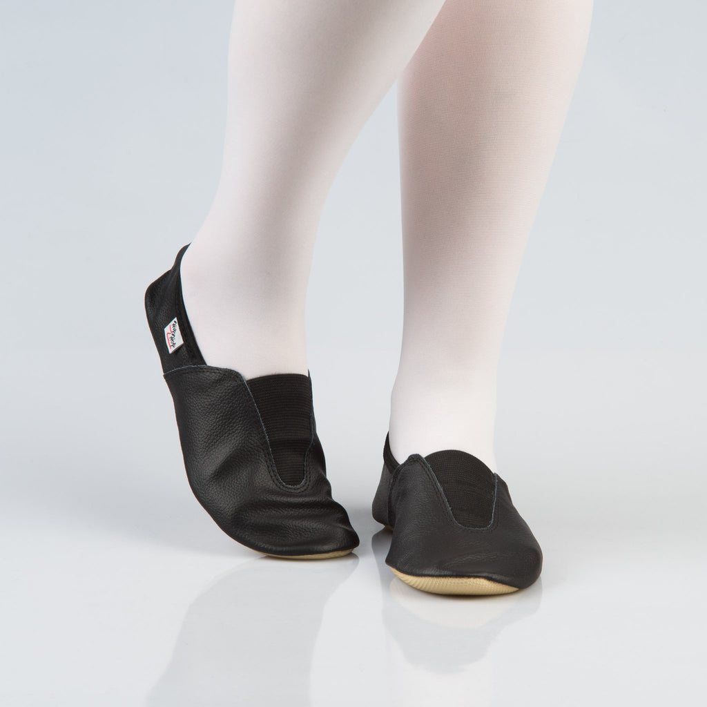 1. Women's black leather gymnastics slippers with rubber detail, worn with white tights, studio setting