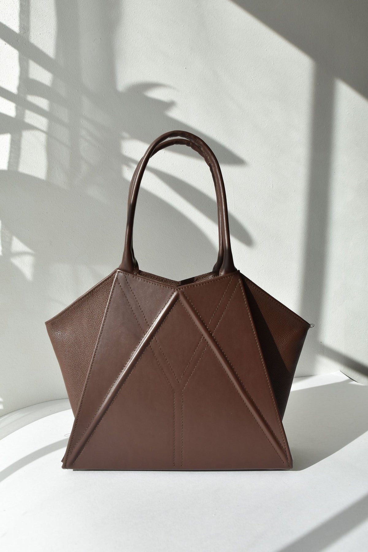 8. Studio shot of Gerda Retter Design Leather Handbag Nova in dark brown, emphasizing its structured form