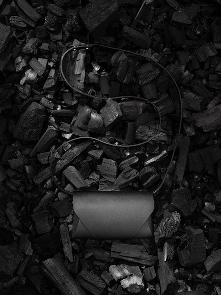 4. Black leather Stella Soomlais Capital of Plenty clutch-wallet on dark textured background