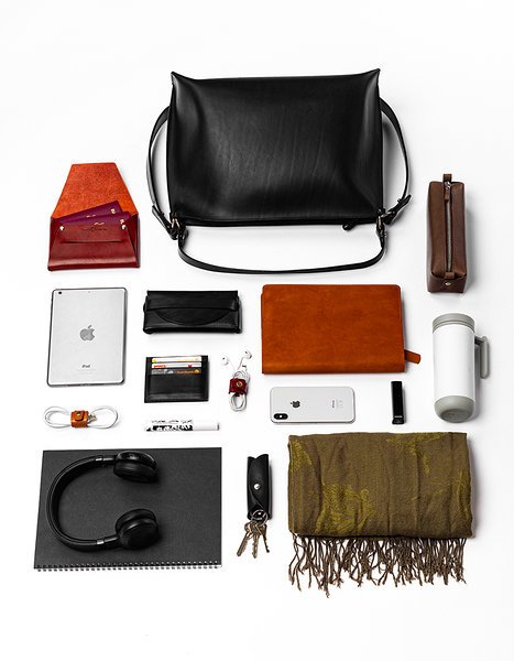6. Flat lay of Stella Soomlais black leather handbag with various items, demonstrating capacity and versatility.