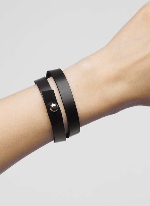 2. Black leather wristband by Stella Soomlais worn on wrist, showcasing double wrap style and silver screw button