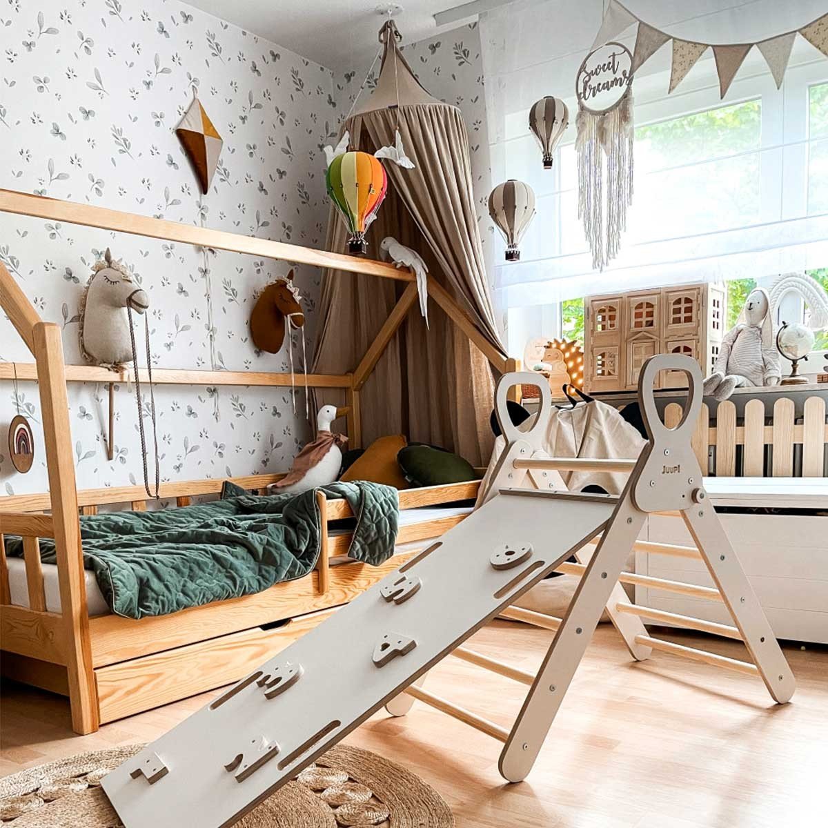 1. Spacious playroom with Dekornik Leaves Minimini wallpaper, wooden climbing frame, and canopy