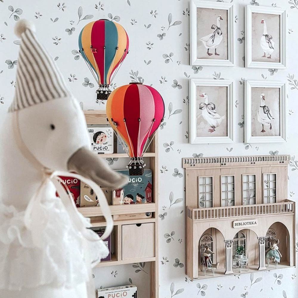 1. Children's room with Dekornik Leaves Minimini wallpaper, hot air balloons, and decorative frames