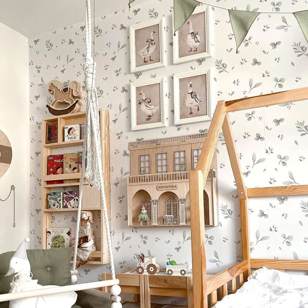 1. Children's play area with Dekornik Leaves Minimini wallpaper, swing, and wooden bookshelf