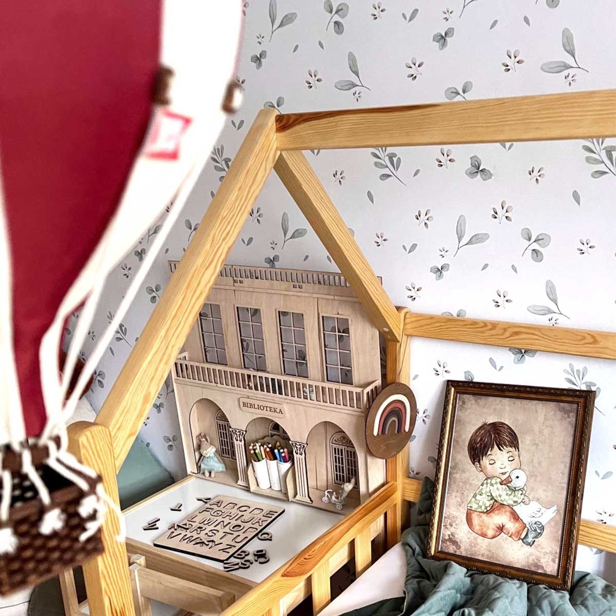 1. Children's room with Dekornik Leaves Minimini wallpaper, wooden house bed, and hot air balloon decor