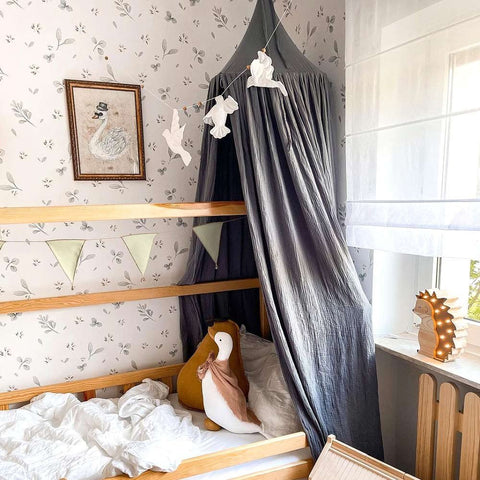 1. Cozy children's bedroom with Dekornik Leaves Minimini wallpaper, canopy, and decorative pillows