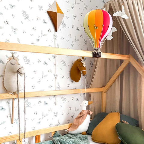 1. Playful children's room featuring Dekornik Leaves Minimini wallpaper, hot air balloon, and plush toys