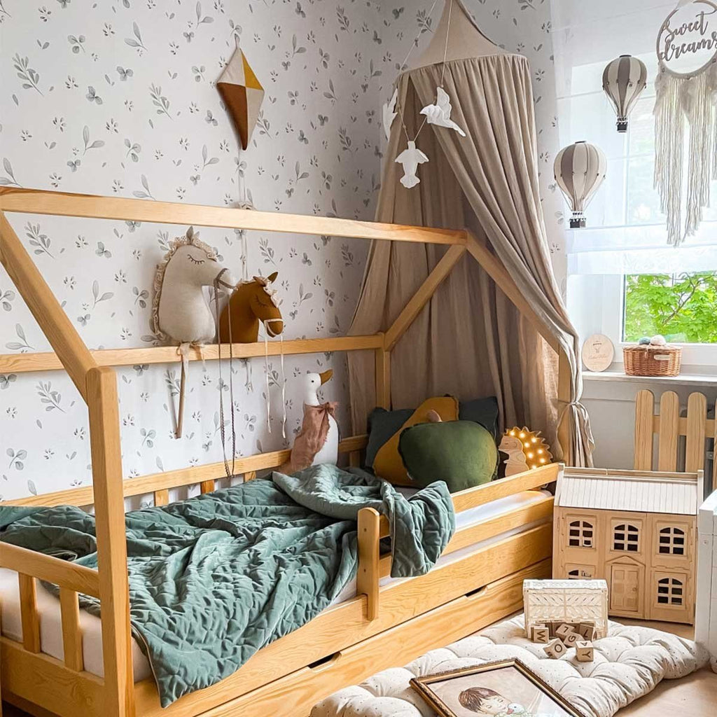 1. Children's bedroom with Dekornik Leaves Minimini wallpaper, canopy, and wooden toys