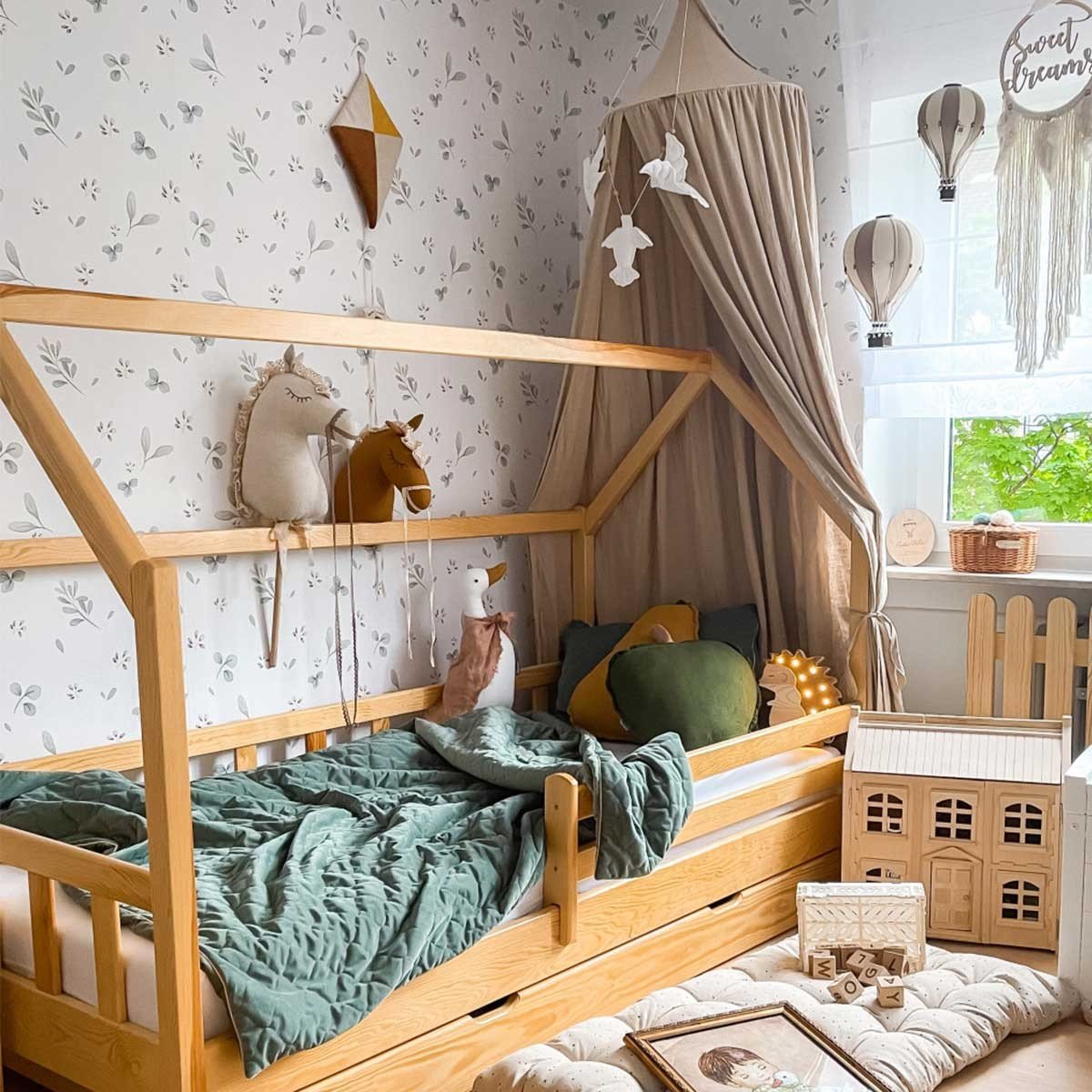 1. Children's bedroom with Dekornik Leaves Minimini wallpaper, canopy, and wooden toys